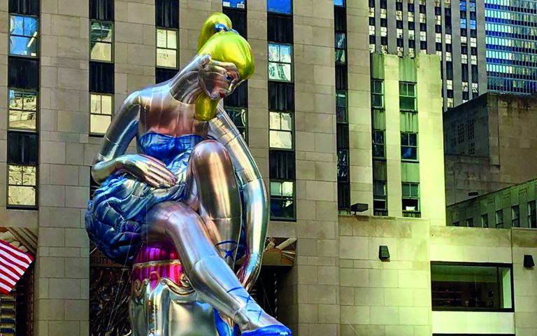 A seated ballerina in the middle of the Rockfeller Center