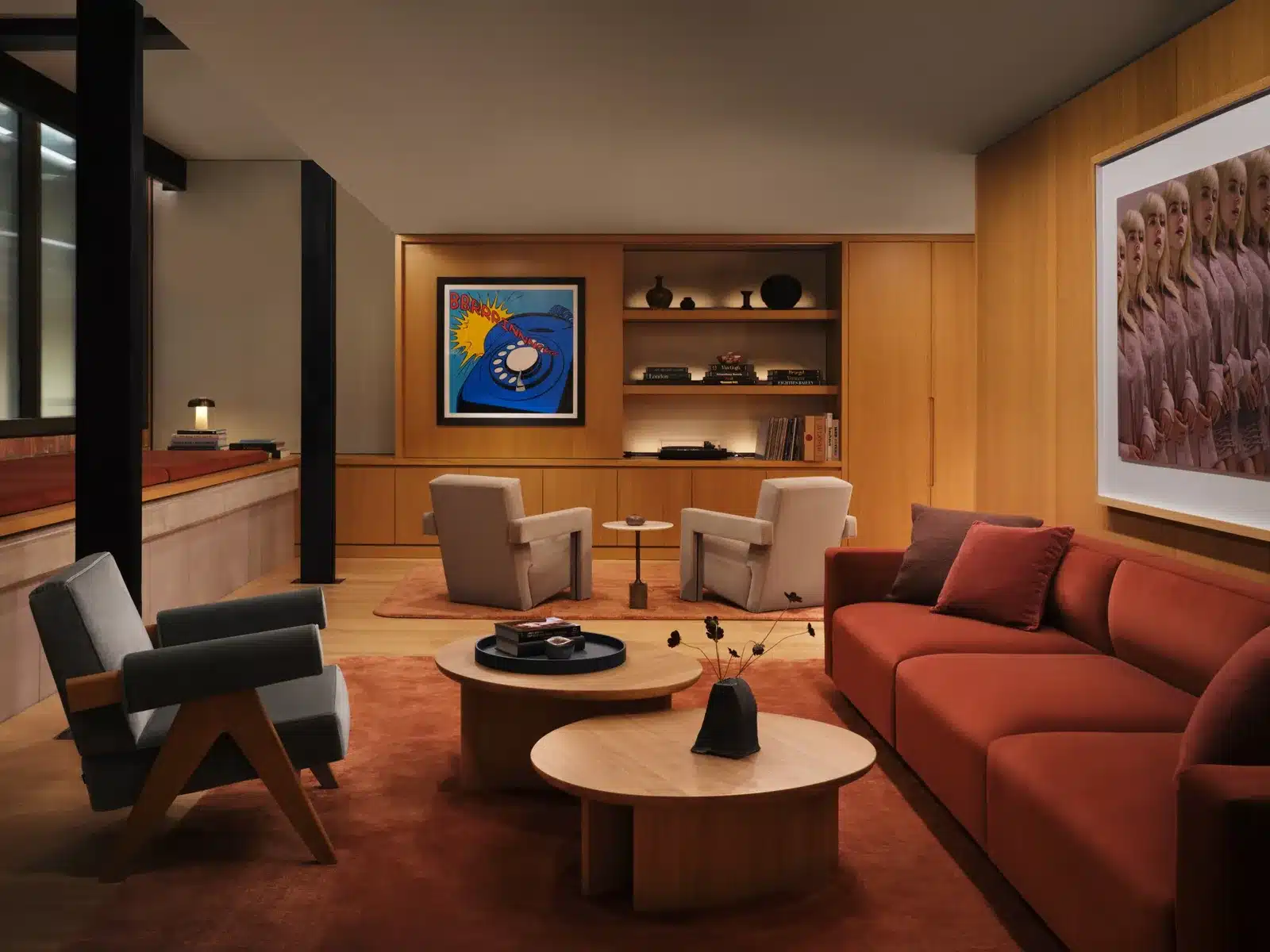 Warm wood-panelled lounge with a red sofa, armchairs and round coffee tables