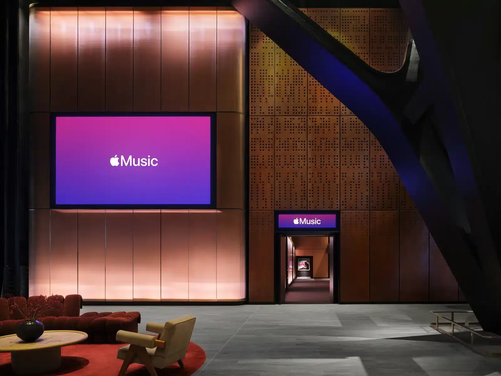 Foyer wall in bronze-toned panels with a large Apple Music screen beside the entrance to the hall