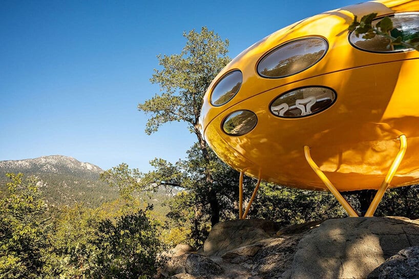 Yellow Futuro shell with oval windows overlooking a mountain valley