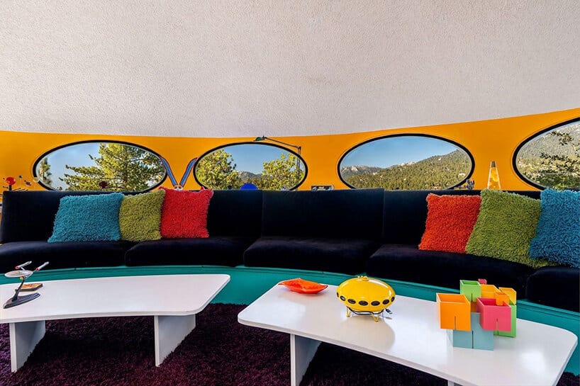 Futuro interior lounge with curved black sofa, colourful cushions and oval windows