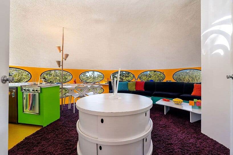 Futuro interior with purple carpet, white round furniture and lime green kitchen