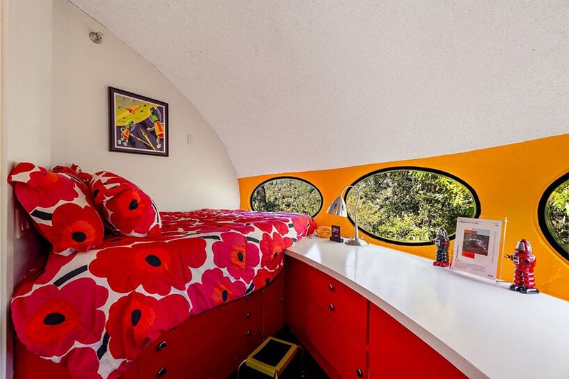 Futuro bedroom with red floral bedding, red cabinets and oval windows
