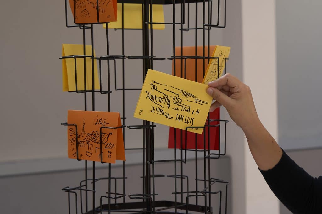 Postcards on a rotating rack in Daniele Catalli’s Saluti e Baci