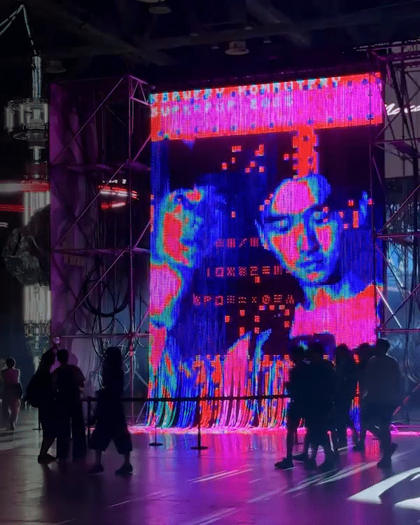 Visitors in front of a large LED installation by Ksawery Komputery