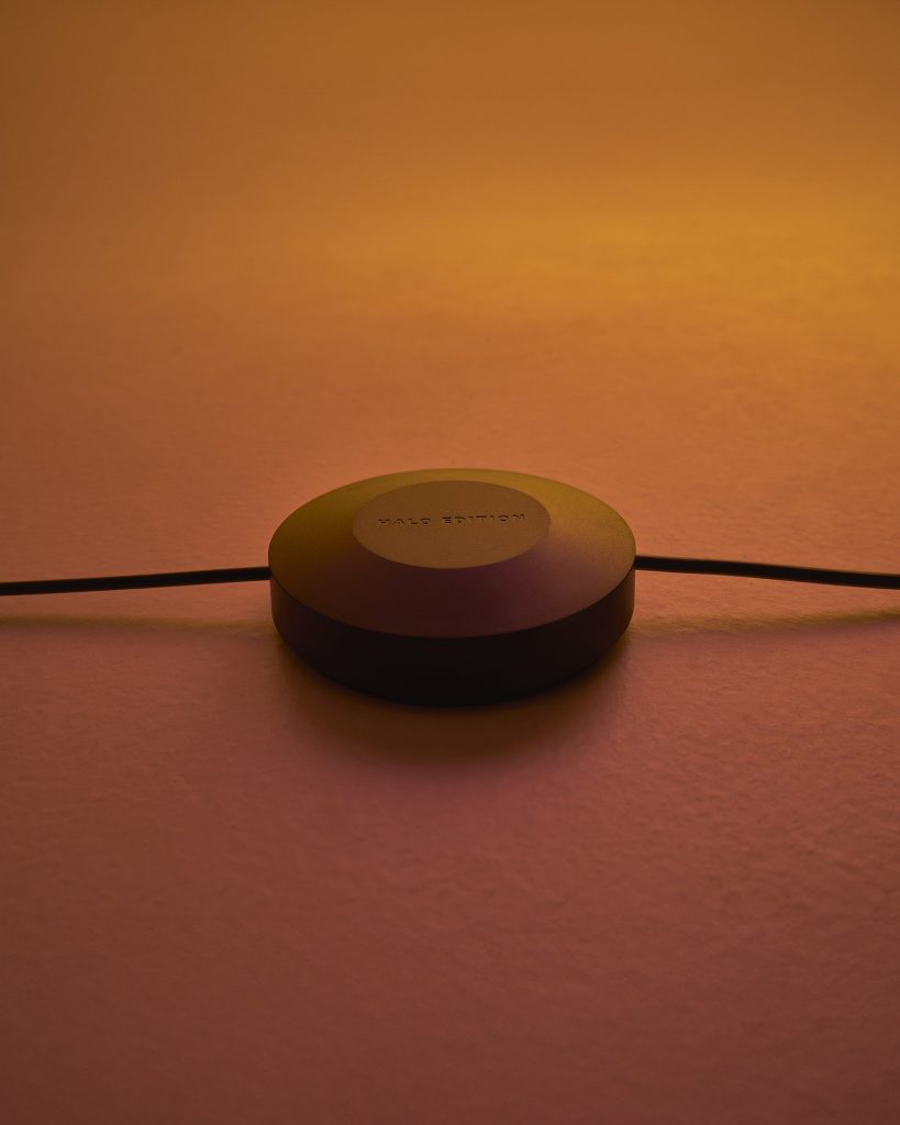 Round Halo Horizon dimmer on its cable in warm orange light