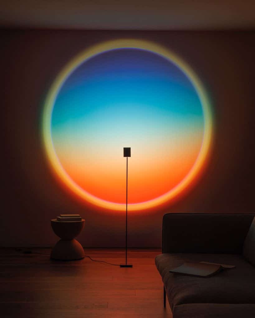 Halo Horizon lamp in a dark living room projecting a large blue and orange circle on the wall