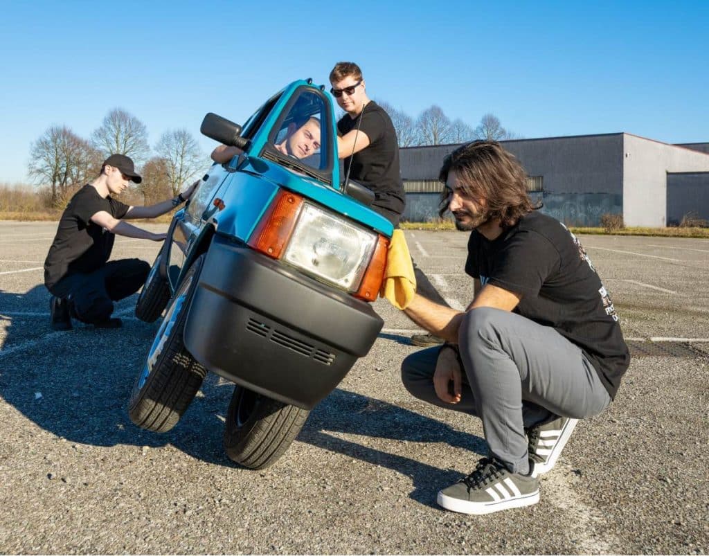 Friends of Andrea Marazzi tipping the Panda per Uno on its side to clean it