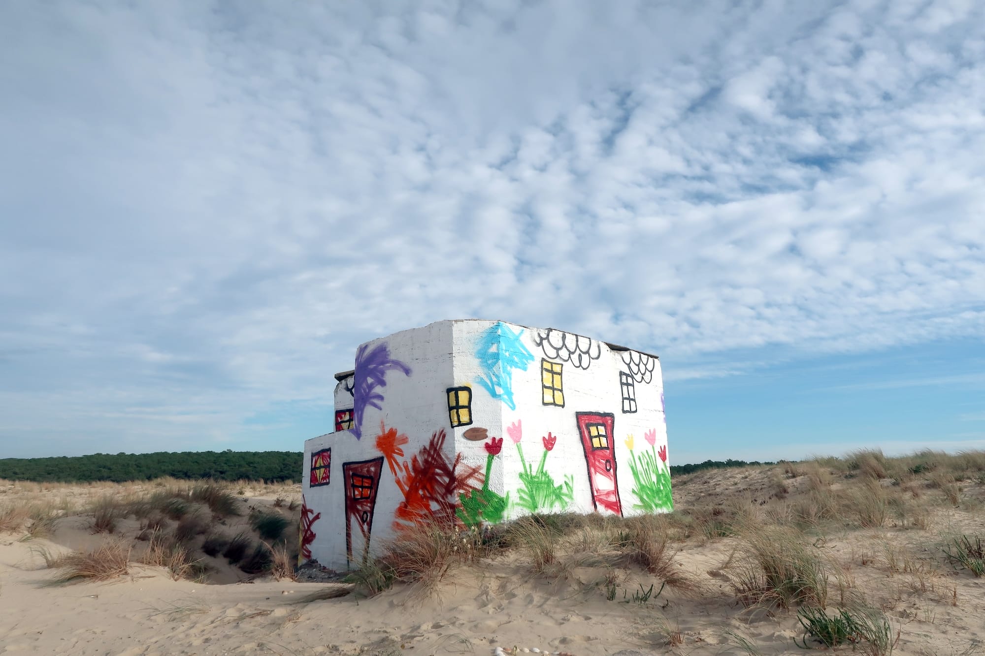 A World War II bunker on the Atlantic Wall painted by The Wa to look like a child's drawing of a house