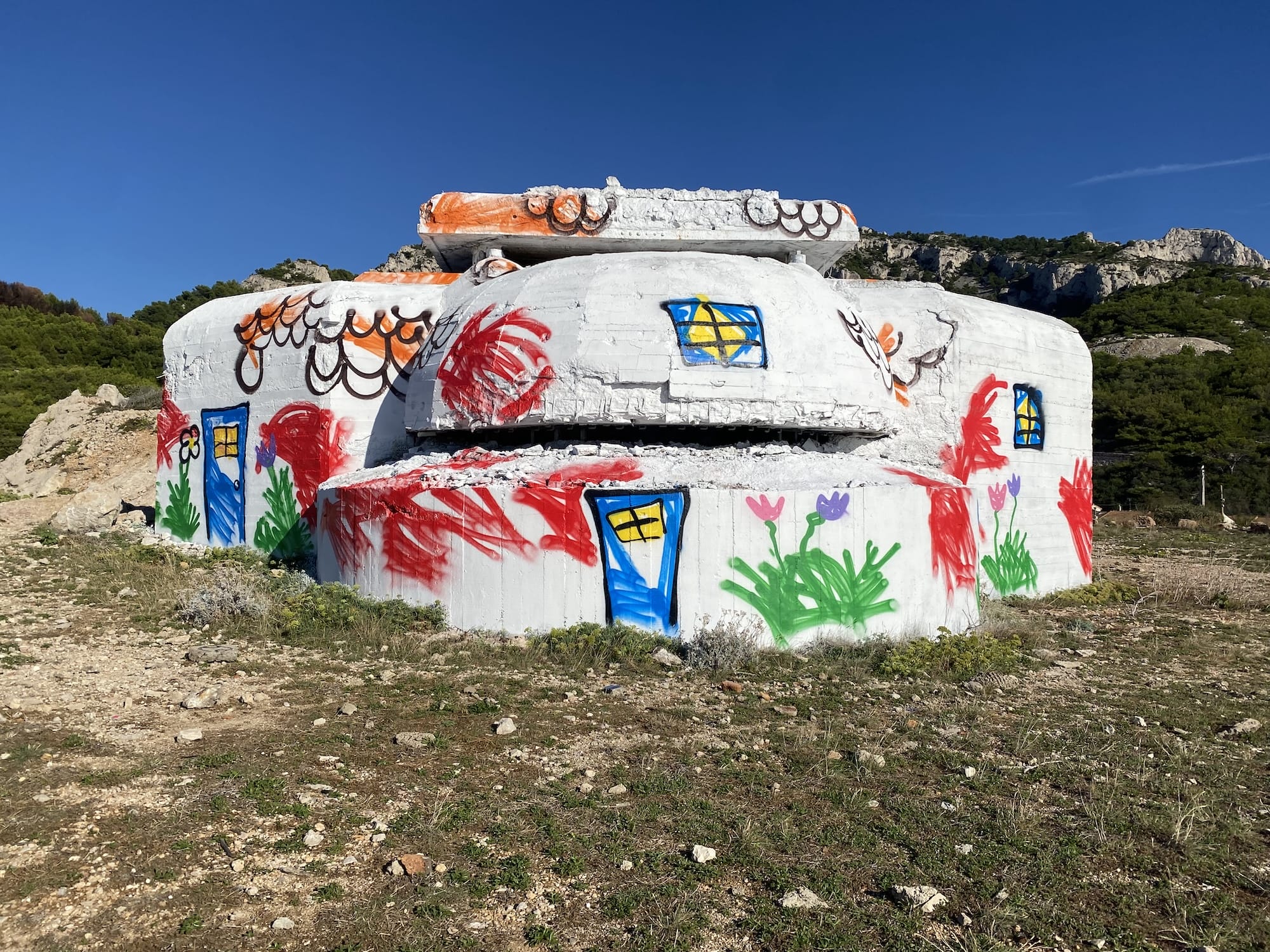 A World War II bunker on the Atlantic Wall painted by The Wa to look like a child's drawing of a house