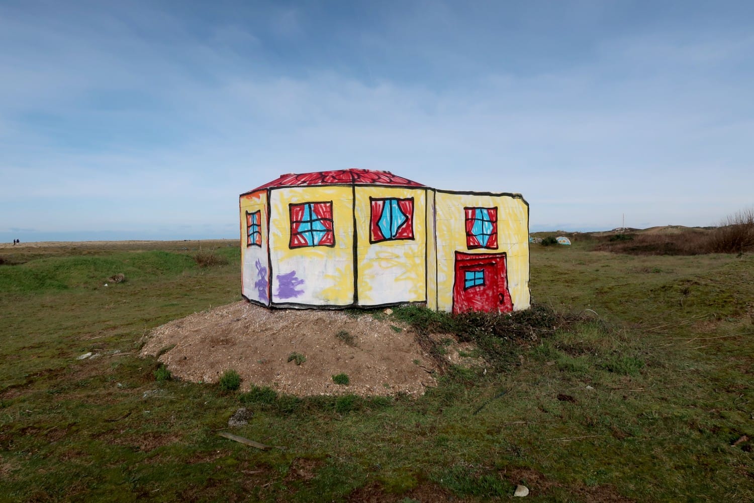 A World War II bunker on the Atlantic Wall painted by The Wa to look like a child's drawing of a house