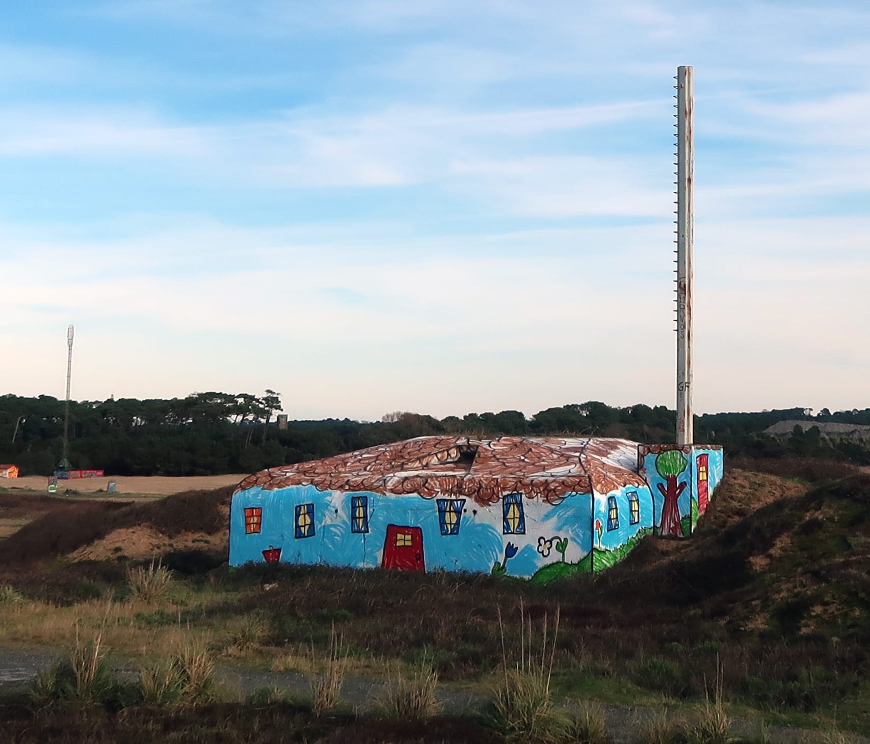 A World War II bunker on the Atlantic Wall painted by The Wa to look like a child's drawing of a house