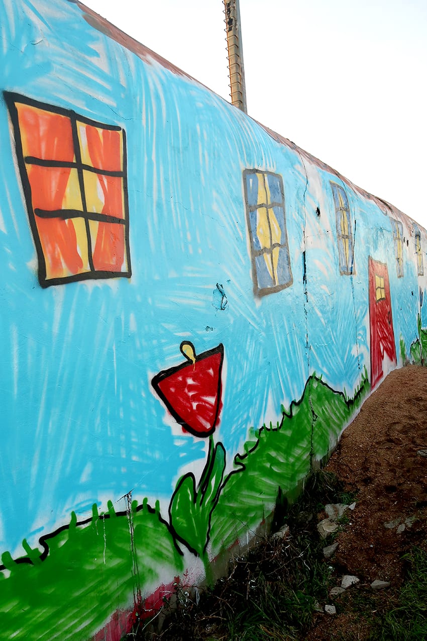 Detail of a World War II bunker painted by The Wa with childlike windows and scribbles