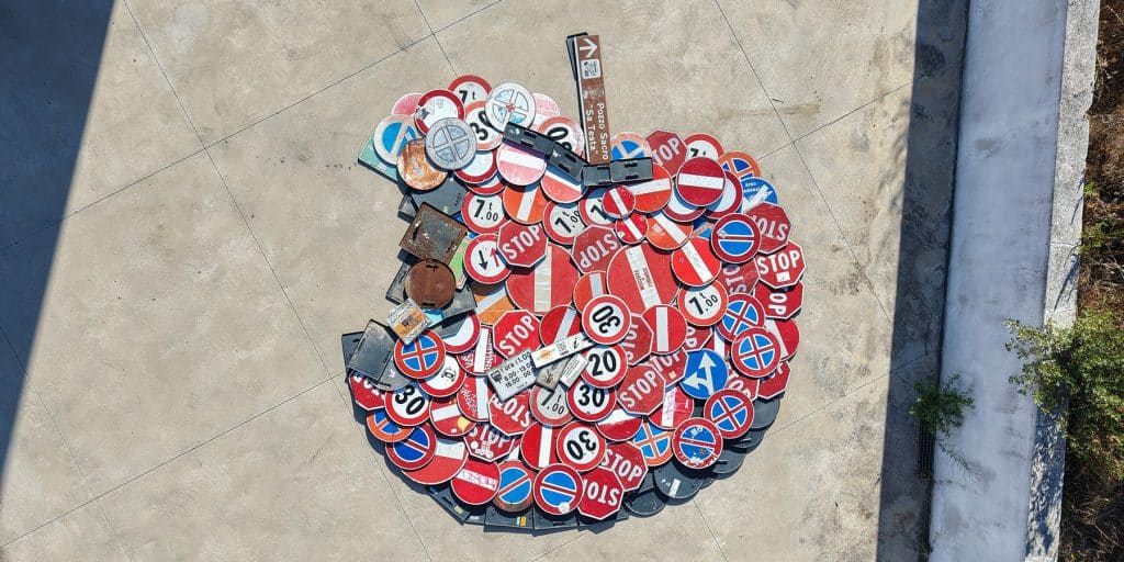 Recovered road signs forming Hokusai’s Great Wave on a beach in Sardinia