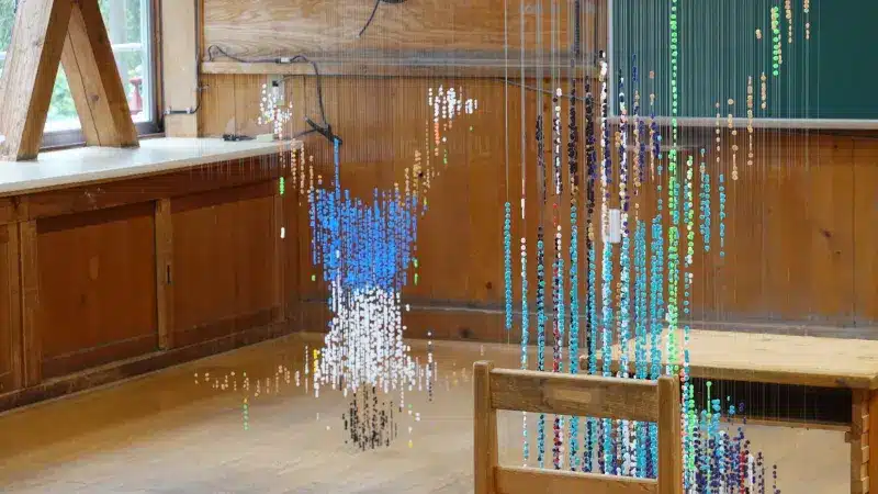 Bead figures among wooden desks and chairs in the former Yuya Elementary School in Gero